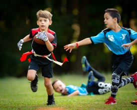 Apex, NC - October 23, 2021 - Ben Anderson (L) scores a touchdown past defenders during a YMCA youth flag football game.(Photo by Jay Anderson / ESPN Images)